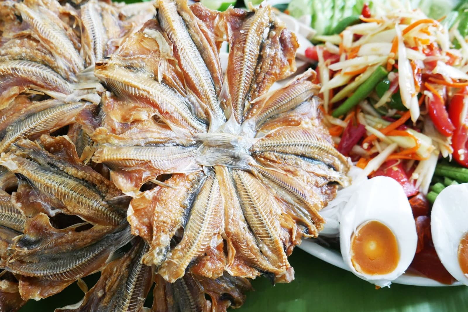 ปลาหัวโม่งทอดกรอบเสิร์ฟกับส้มตำและไข่ต้ม